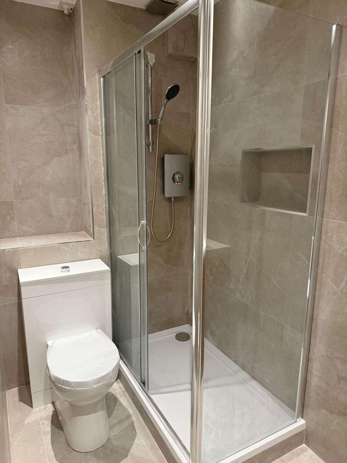 Stone-tiled shower with toilet
