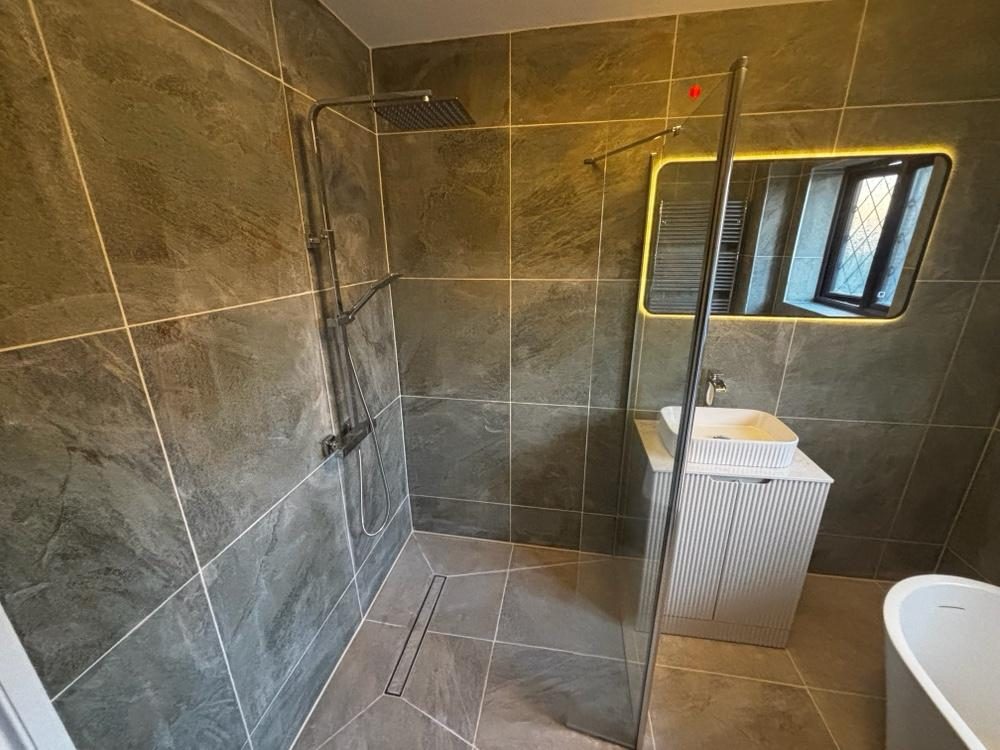 Green and star-tile bathroom with wall-hung basin