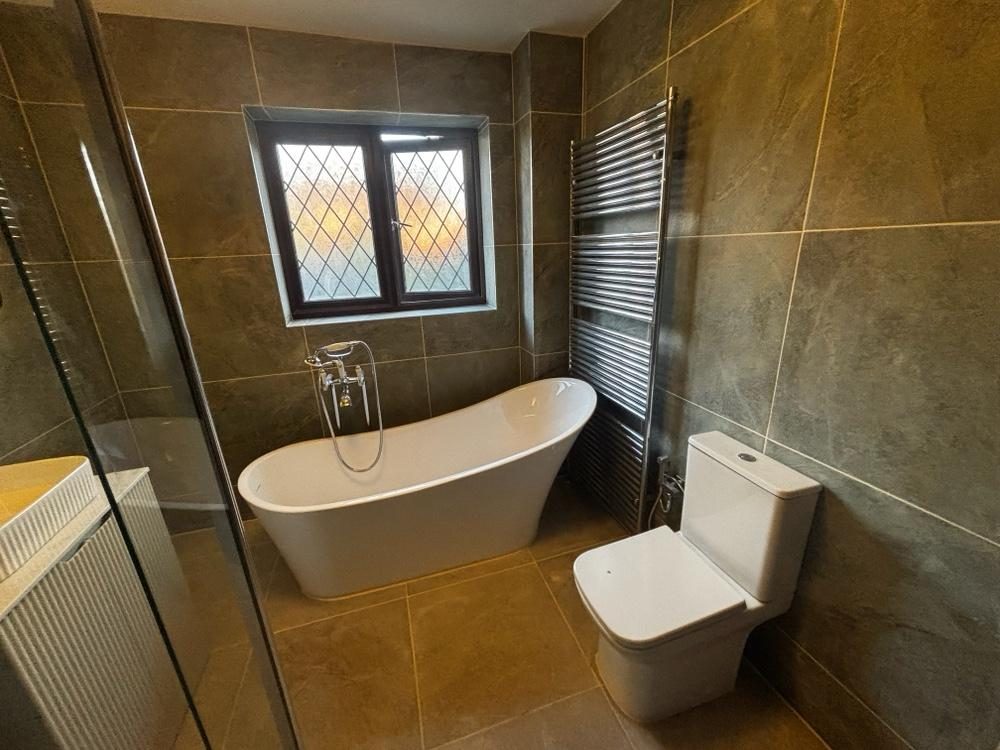 Kitchen with green metro tiles and wood worktop