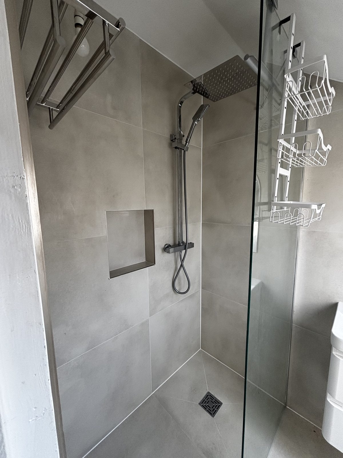Walk-in shower with recessed niche and rainfall head in loft ensuite